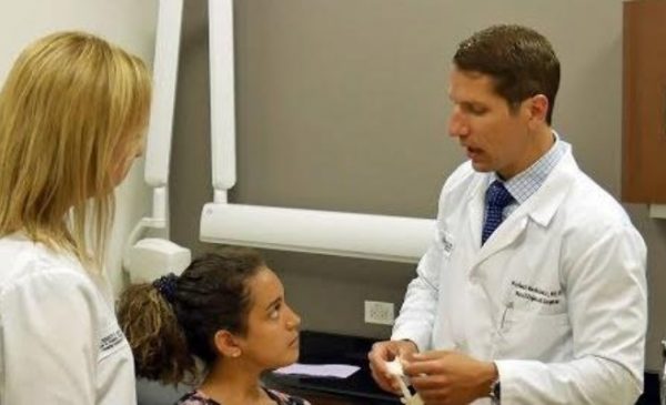 a dentists speaking with child and woman