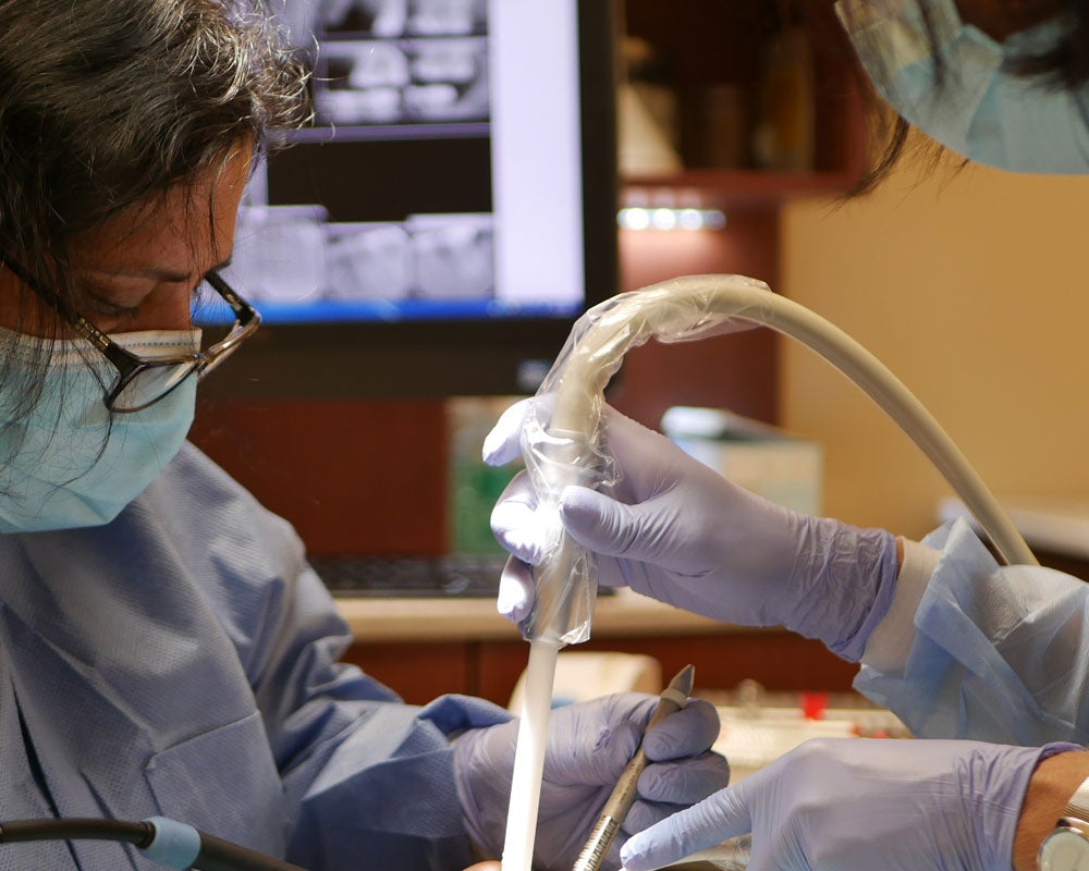 two dentists working on a clients teeth