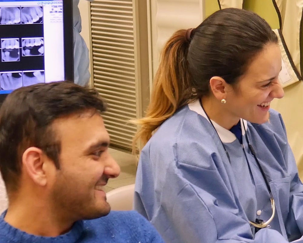 dentist and patient smiling off camera