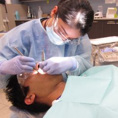 student dentist working on patient's mouth