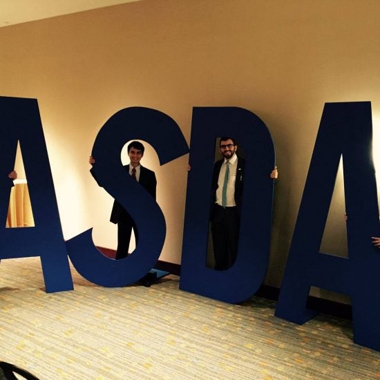 Students standing with large letters A S D A