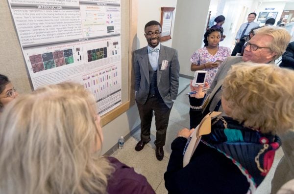 man presenting research in front of crowd