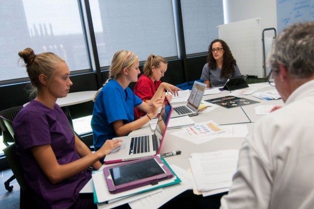 group of dentists in front of their laptops