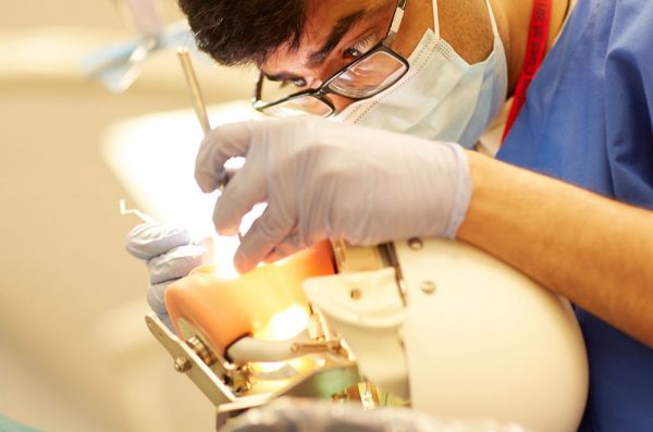 dental student practicing on a patient model