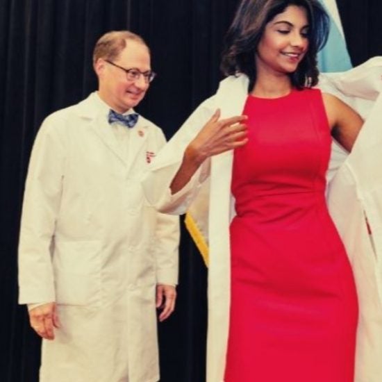 woman receiving white coat