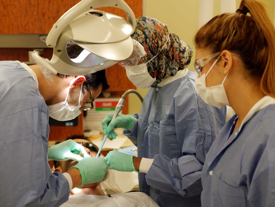 three dentists working on patient