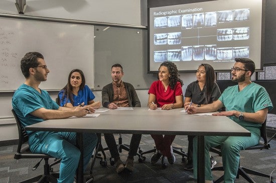 student dentists sitting at conference table