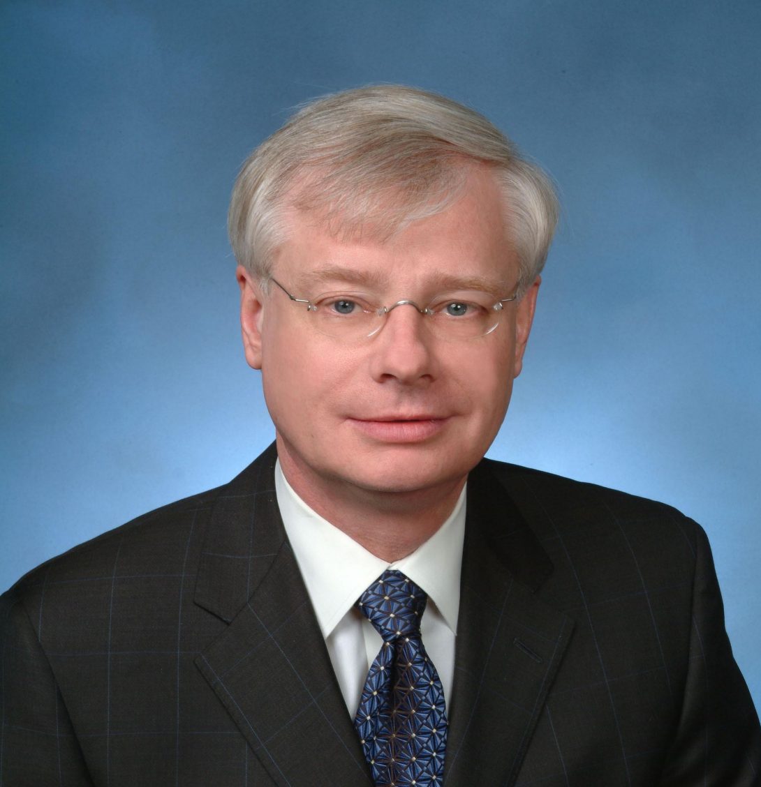 Dr. Graham wearing a black suit and a blue tie