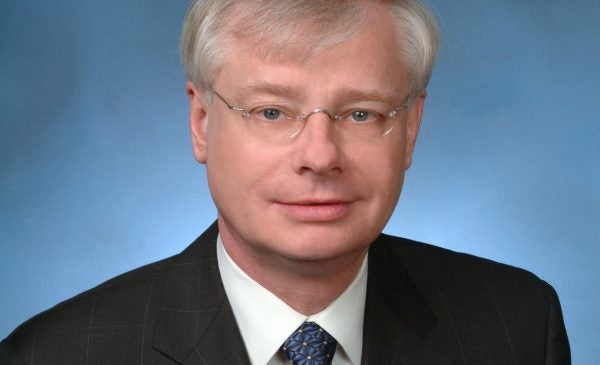 Dr. Graham wearing a black suit and a blue tie