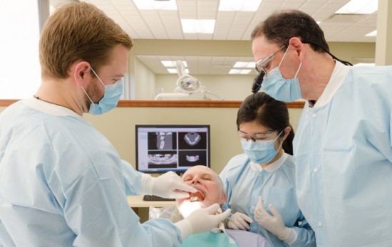 three dentists working on patient
