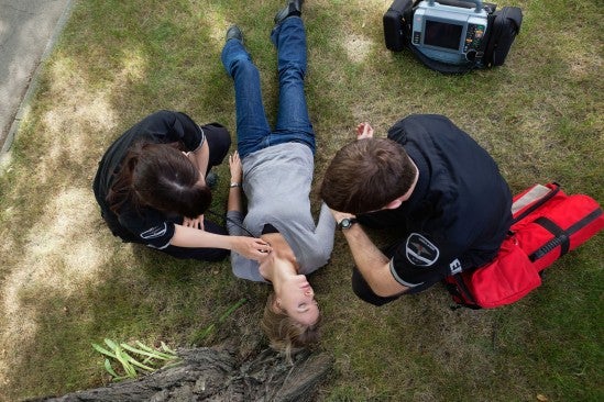 two people helping a passed out woman