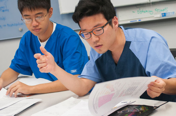 two students reading a packet