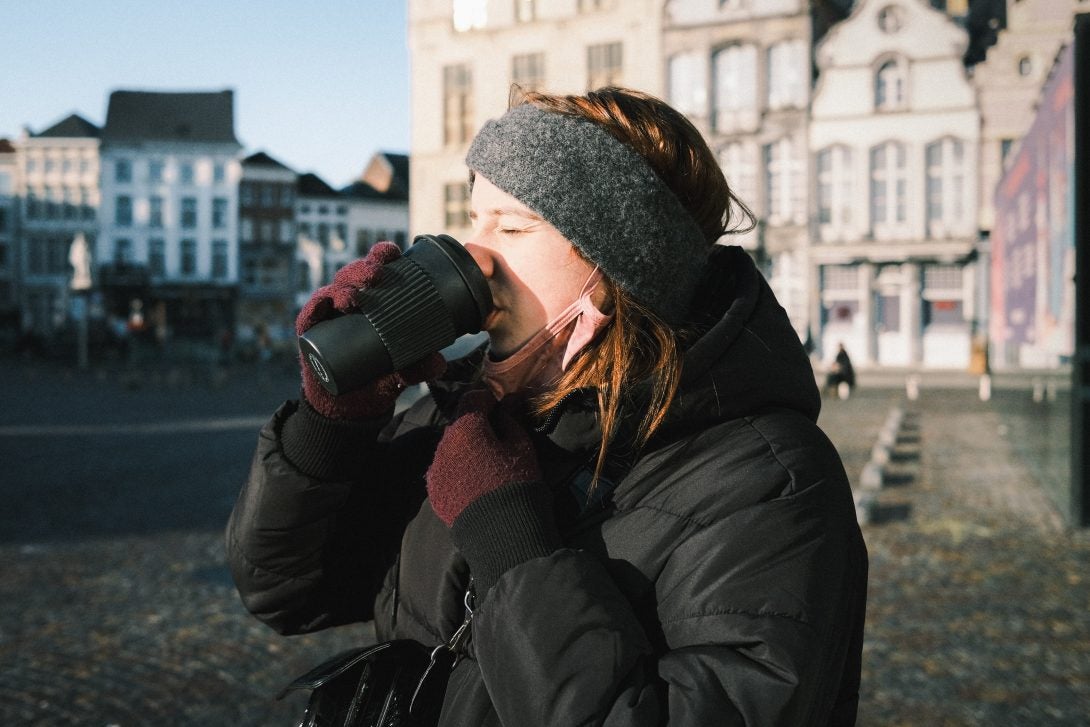 woman drinking out of a coffee cup