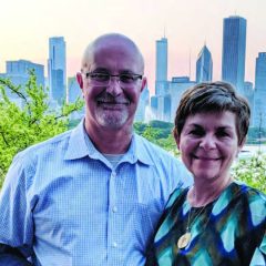 Dr. Roucka and her husband posing in front of the Chicago skyline