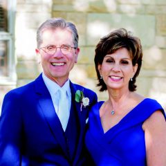 Dr. Rowan and her husband posing against a white wall