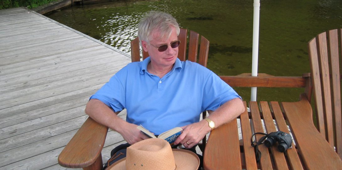 Dr. Graham seated outside, reading a book