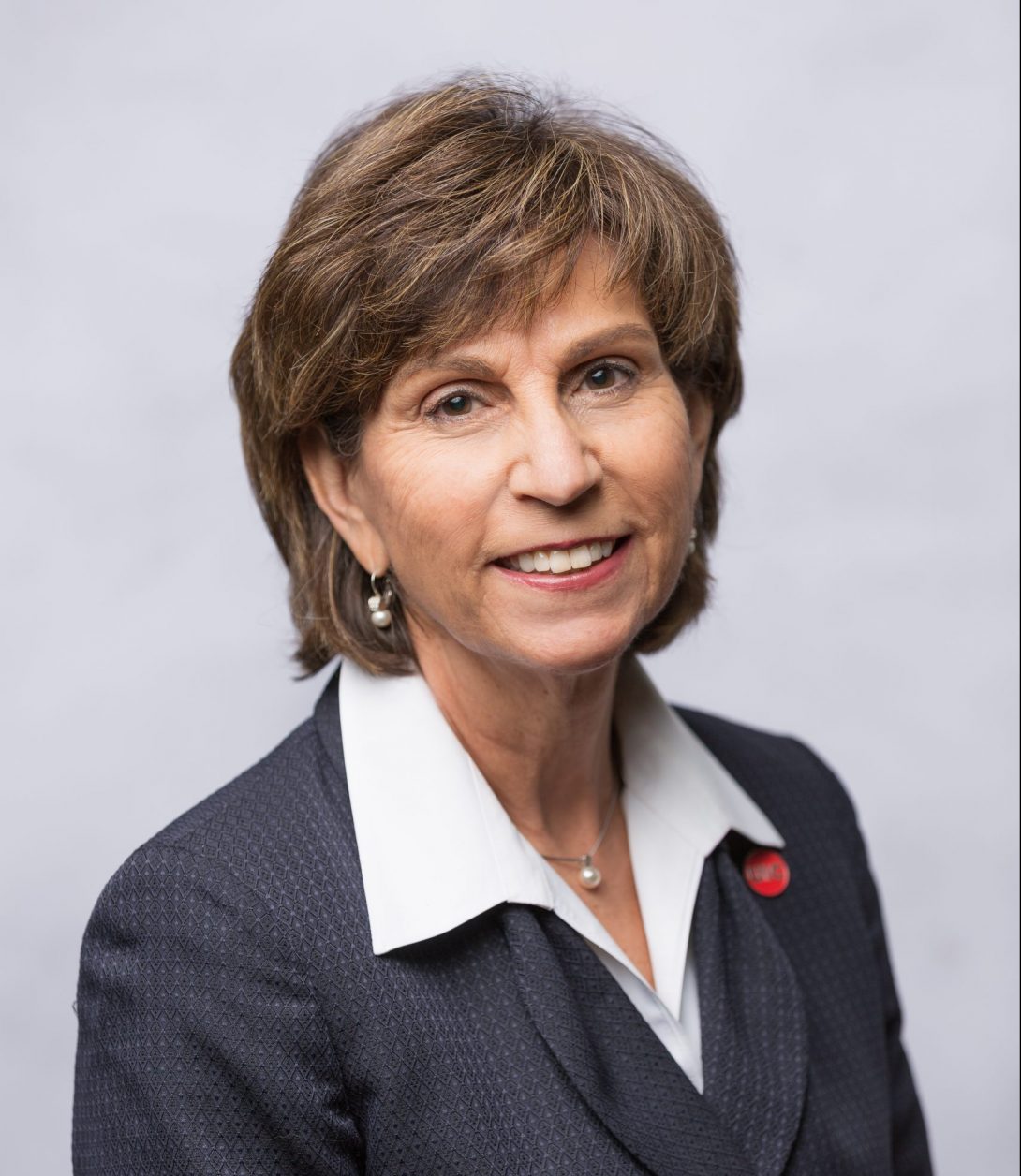 Dr. Susan Rowan wearing a navy jacket with a red UIC pin