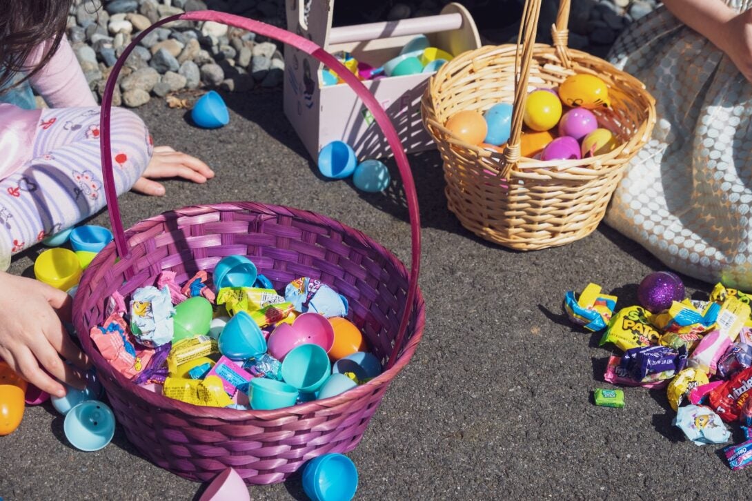 Pink and tan easter baskets filled with multi-colored plastic eggs and candy