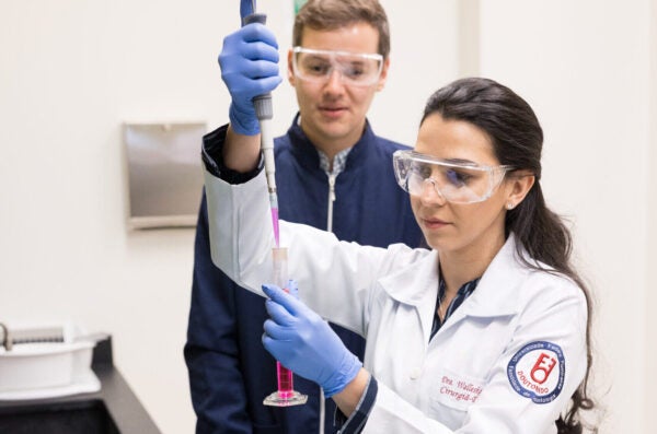 research students using a syringe to put solution into a new container