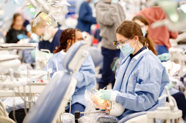 woman wearing a lab coat, seated in the clinics