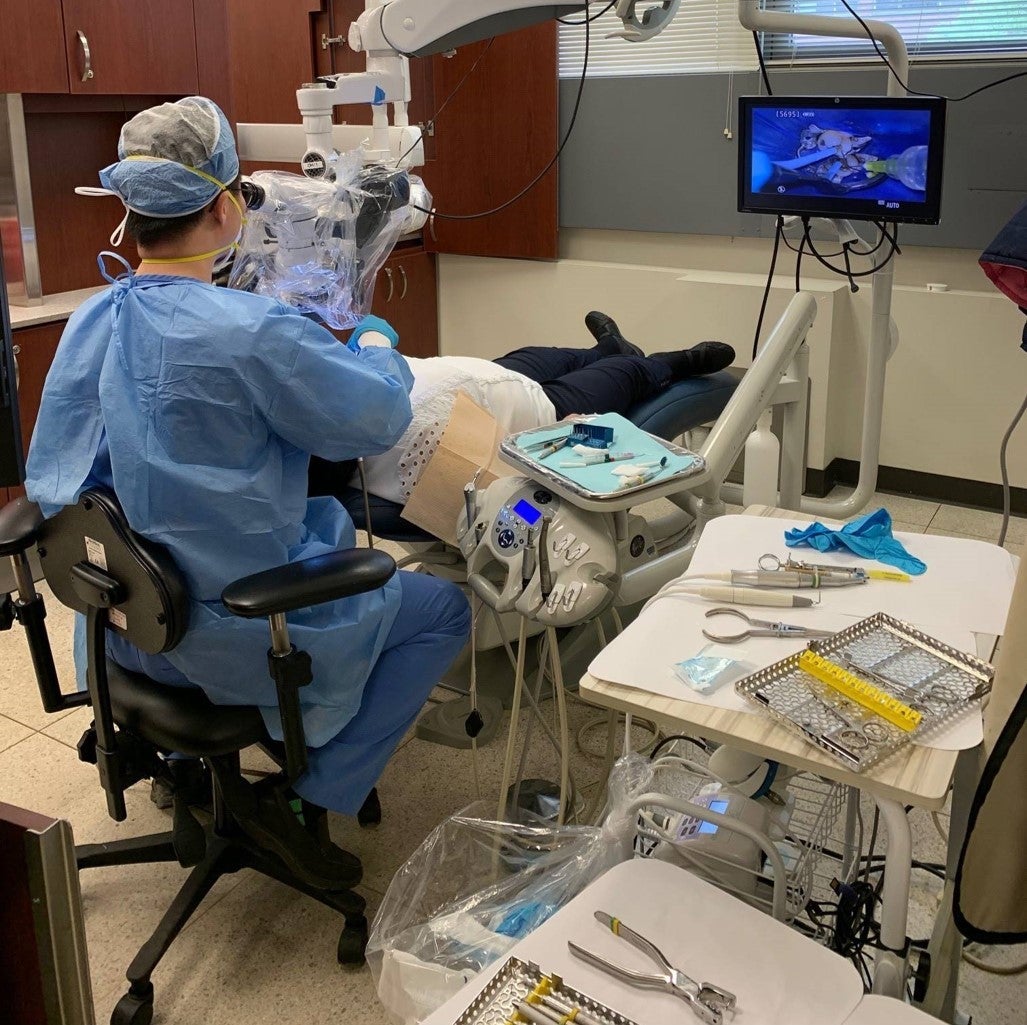 dentist wearing blue scrubs working in the endo clinic