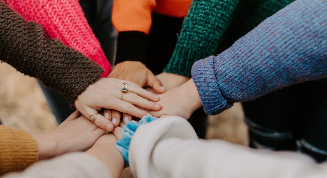 A group of women putting their hands together in a huddle