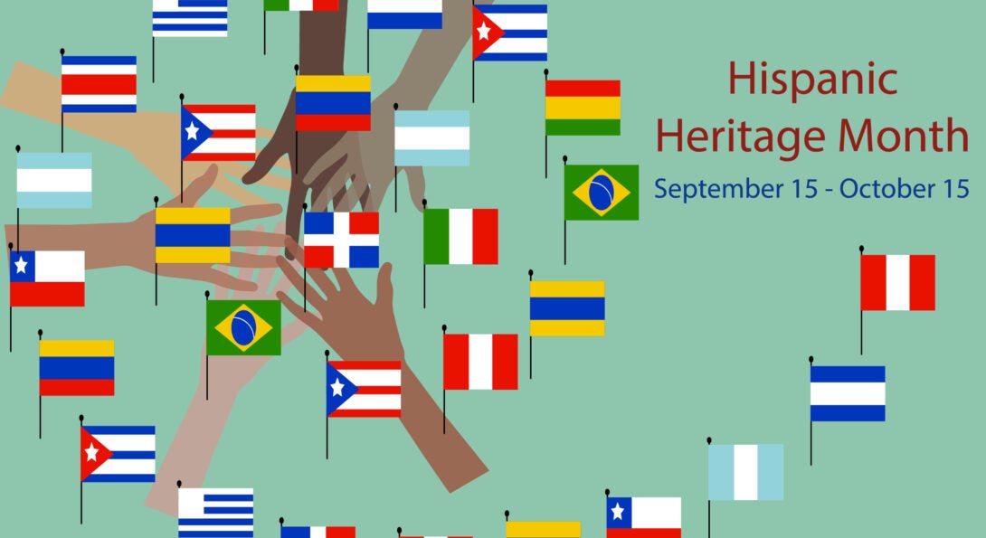 Hands holding various Hispanic flags.