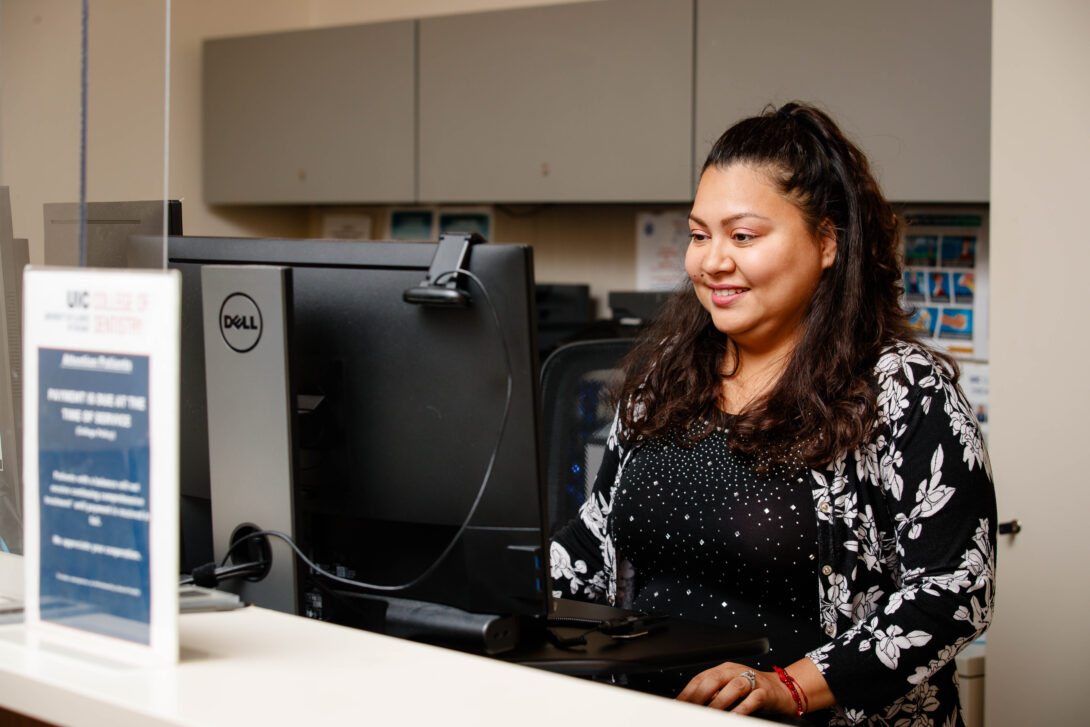Woman standing at desk in front of computer