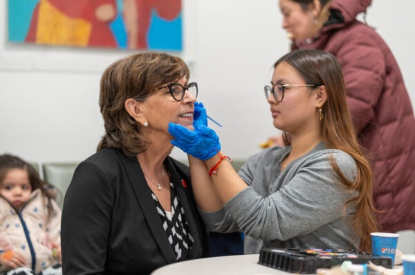 Dean Susan Rowan gets face painted by volunteer