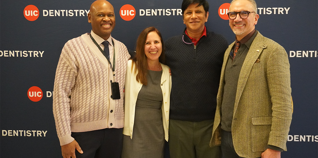 Group pose in front of blue UIC Dentistry backdrop