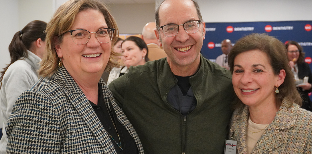 Three classmates smiling at welcome reception